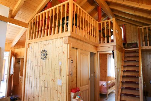 a wooden cabin with a staircase in a room at Charmante maisonnette avec vue sur les montagnes in Chalais