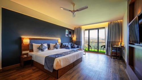 罗纳瓦拉Ikshana Resort and Spa, Khandala的一间带大床和大窗户的卧室