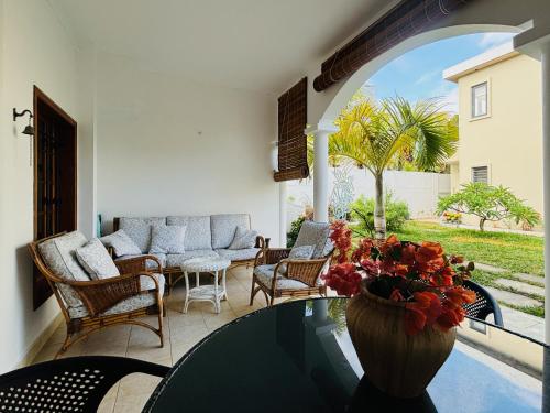 a glass table with a vase of flowers on a patio at Beachfront Villa Miramar in Pointe d'Esny
