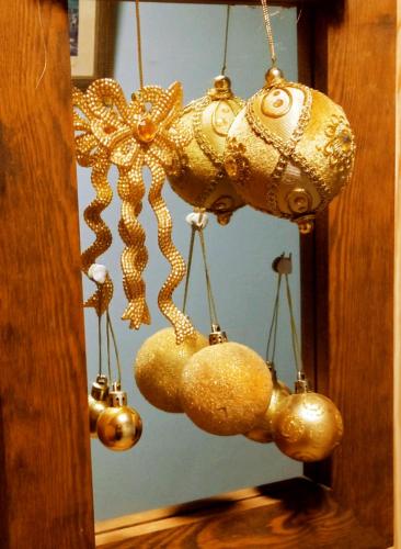 a bunch of gold ornaments hanging from a mirror at Les Terrasses Chambre d'Hôtes in Huelgoat