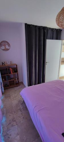 une chambre avec un lit violet et une fenêtre dans l'établissement O Brésis d'Ales!, à Alès