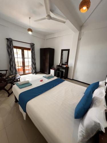a large bed in a room with two pillows on it at PRANA Beach Hotel Hikkaduwa in Hikkaduwa