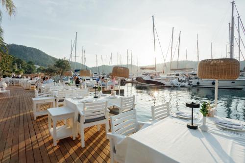 a group of tables and chairs on a dock with boats at Yacht Classic Hotel - Boutique Class in Fethiye