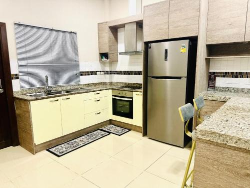 a kitchen with a stainless steel refrigerator and a sink at 木林民宿 in Ban Bung