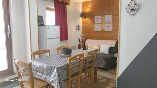 une cuisine et une salle à manger avec une table et des chaises dans l'établissement Appartement proche piste et près de l'Ecole de Ski, à Chamrousse