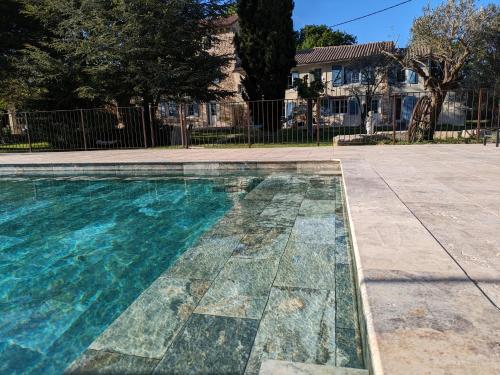 アヴィニョンにあるMas de la Roule, 4 studios, piscine chauffée, studio SPA, parc 2 ha, Pont d'Avignon à piedの庭園内のモザイクフロアのスイミングプール