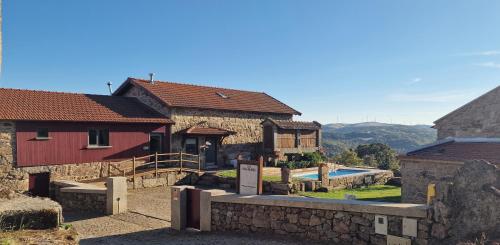 a group of buildings with a pool in the middle at Casa Entre-Palheiros e Casa do Canastro in Montalegre