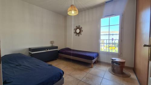 MARINA DEL SOL Aigues Mortes في إج مورت: غرفة نوم بسرير ازرق ونافذة
