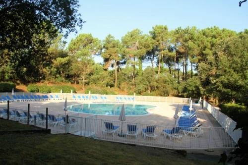 una piscina con sedie blu e recinzione di appartement soustons plage a Soustons