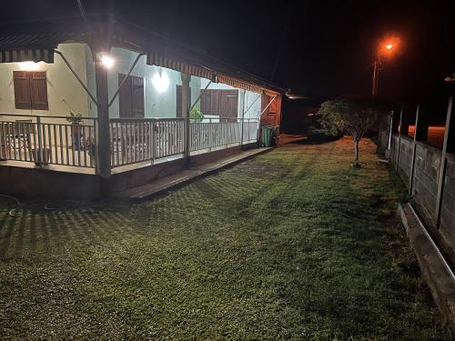 a house at night with a yard in front of it at CosyLife Sainte-Rose - Villa familiale calme avec vue Sofaïa à 3km de la plage in Sainte-Rose
