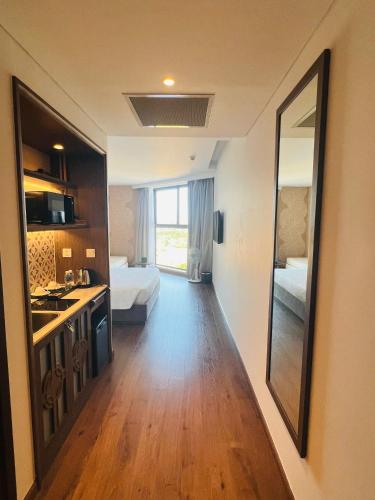 a room with a bedroom with two beds and a mirror at Apec Mandala Cham Bay Condotel Mui Ne in Mui Ne