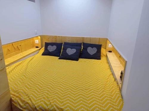 - un petit lit avec 2 oreillers bleus dans l'établissement Location saisonnière 4 couchages, à Villard-de-Lans