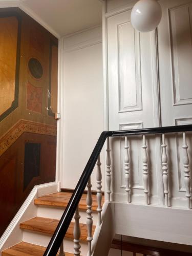 a staircase in a home with a white stair case at Townhouse in Odense