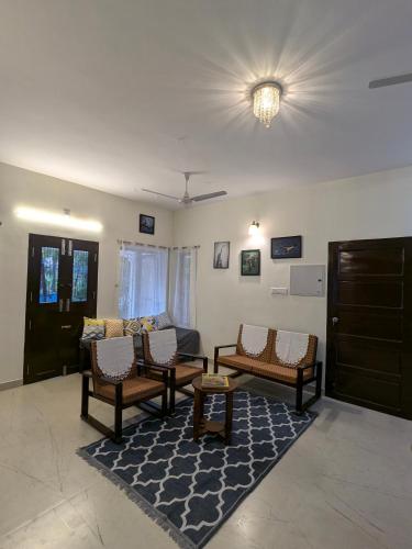 a living room with a couch and chairs and a rug at Oyster Lily, 2BHK in Ngl City Centre, Calm Area in Nāgercoil