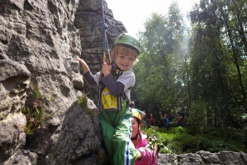 a young boy in a helmet climbing a rock wall at Guest House Sněžník in Sněžnik