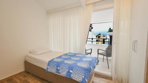 a small bedroom with a bed and a balcony at Anatolian Homes & Apart in Antalya