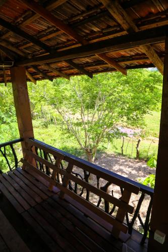 a bench on a porch with a view of a tree at Go Yala Farm Villa in Tissamaharama