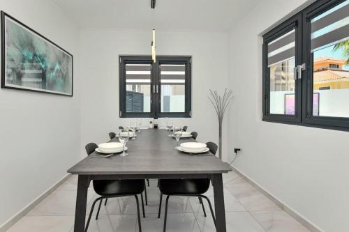 a dining room with a wooden table and chairs at New Villa Luel 5 minutes from Palm Beach in Noord