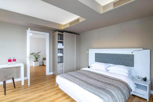 a bedroom with a bed and a table and a desk at Alliance Palace Marriott in Batumi