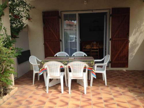 une table et des chaises assises sur une terrasse dans l'établissement Maison 6 personnes plage à 5min, à Port-la-Nouvelle