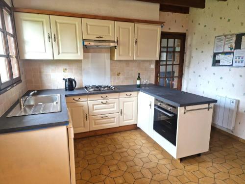 une cuisine avec des armoires blanches et un comptoir noir dans l'établissement Maison spacieuse à Saint-Josse, à Saint-Josse
