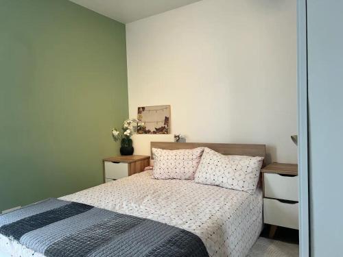 une chambre avec un lit et un mur végétal dans l'établissement Appartement chaleureux aux portes de Paris, à Ivry-sur-Seine