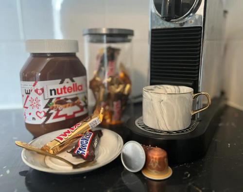 un comptoir avec un bocal de nutella et une tasse de café dans l'établissement Appartement chaleureux aux portes de Paris, à Ivry-sur-Seine