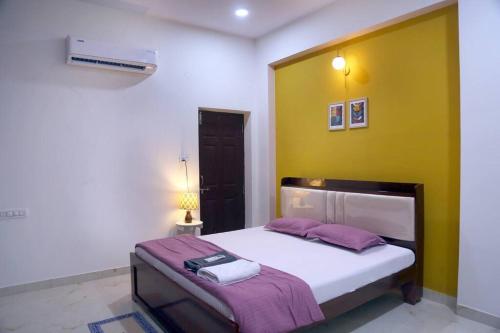 ハイデラバードにあるVeetil -3BHK AC, Kukatpally, Hyderabadのベッドルーム1室(黄色い壁のベッド1台付)