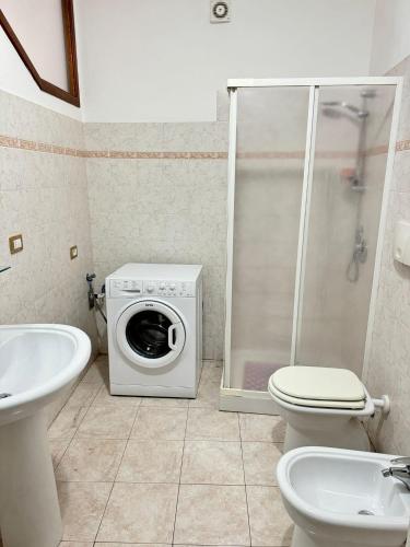 a bathroom with a washing machine and a toilet at Casa Antonietta - SHARDANAPARTMENTS in Iglesias