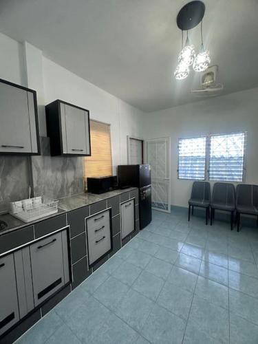 a kitchen with a counter and chairs in a room at P&I Group Home 4 Karon beach in Karon Beach