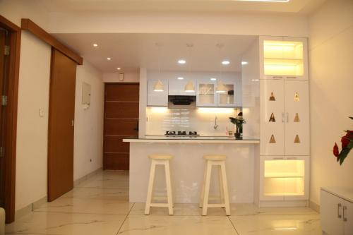 a kitchen with a counter and stools in a room at The Crystal Apartment in Trivandrum