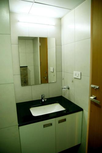 a bathroom with a sink and a mirror at The Crystal Apartment in Trivandrum