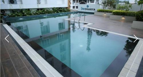 a swimming pool with blue water in a building at The Crystal Apartment in Trivandrum