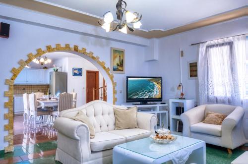 a living room with two white couches and a table at Sea View Villa Paramonas in Paramonas