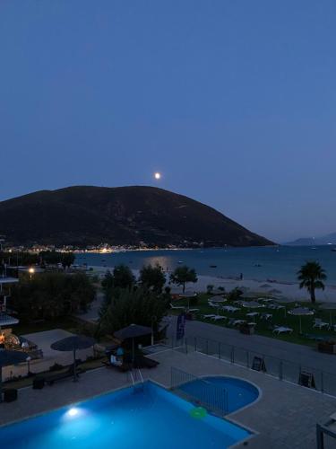 a view of a pool and the beach at night at Surf Hotel in Vasiliki