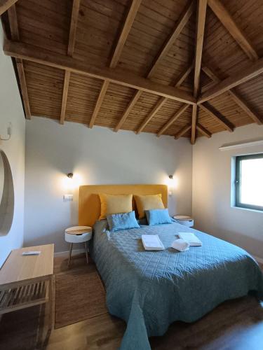 a bedroom with a large bed with a wooden ceiling at Casa dos Matos in Ponte de Lima