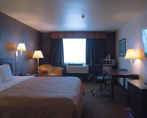 a hotel room with a bed and a desk and a window at Quality Inn & Suites Yuma in Yuma