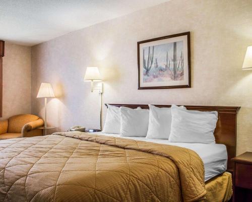 a hotel room with a large bed with white pillows at Quality Inn & Suites Yuma in Yuma