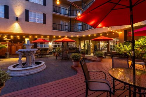un patio con una fuente, mesas y sombrillas en Quality Inn Downtown Inner Harbour, en Victoria