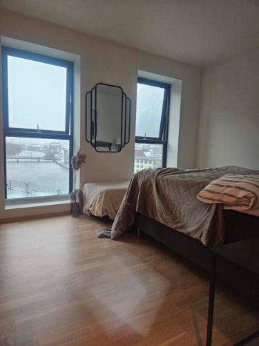 a bedroom with two beds and a tv on the wall at Toppleilighet på elvekanten med to romslige soverom in Førde