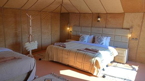 a bedroom with a large bed in a tent at La Sultana Luxury Camp in Merzouga