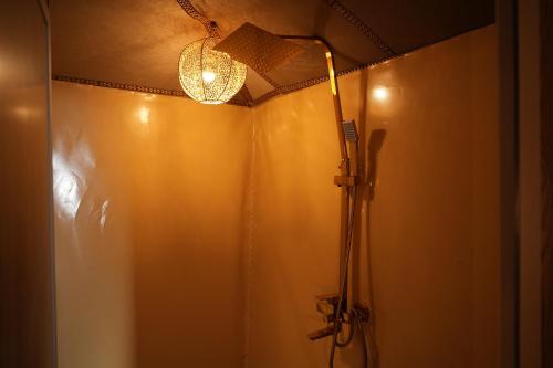 a bathroom with a shower with a light at La Sultana Luxury Camp in Merzouga