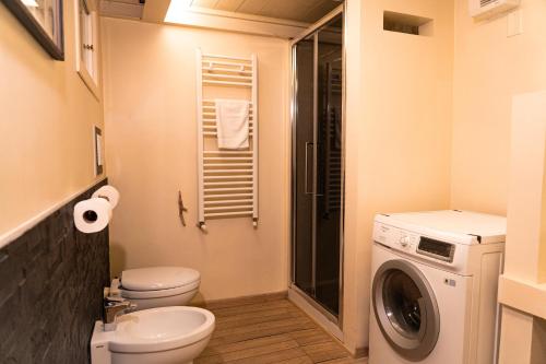 a bathroom with a toilet and a washing machine at Old Town Nest in Civitavecchia in Civitavecchia