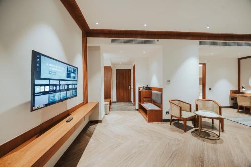 a living room with a flat screen tv on a wall at Wyndham Garden Sonipat Murthal in Sonīpat