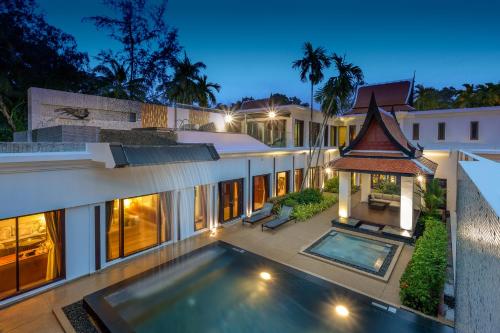 an external view of a house with a swimming pool at Maikhao Dream Villa Resort and Spa, Maikhao Phuket in Mai Khao Beach