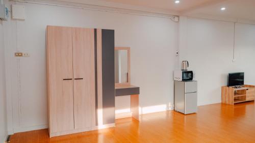 a large wooden cabinet in an empty room with a television at P&I Group Nana apartments 2&3 in Karon Beach