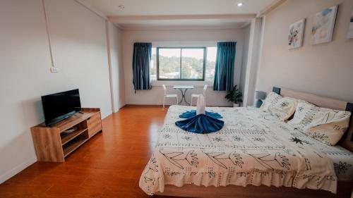 a bedroom with a bed and a television in it at P&I Group Nana apartments 2&3 in Karon Beach