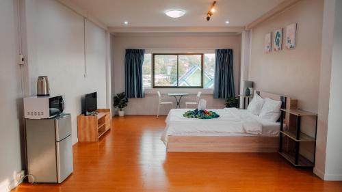 a bedroom with a large white bed and a television at P&I Group Nana apartments 2&3 in Karon Beach