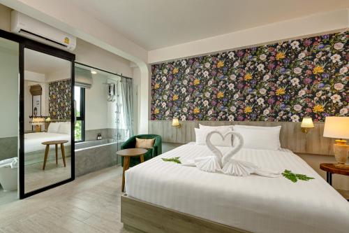 a hotel room with a bed with a heart on it at Ang Pao Hotel Phuket in Phuket Town