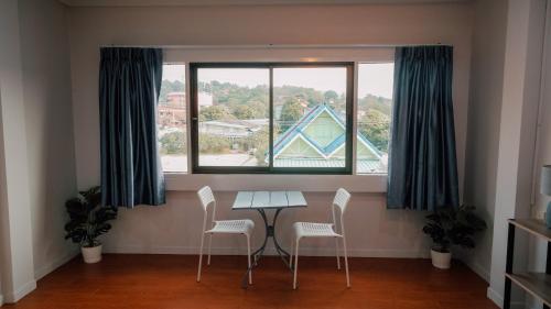 a table and chairs in a room with a large window at P&I Group Nana apartments 2&3 in Karon Beach